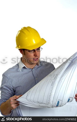 Young Businessman wearing a hard hat is reviewing construction blue prints.