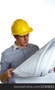 Young Businessman wearing a hard hat is reviewing construction blue prints.