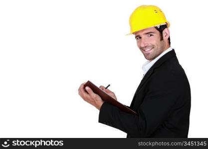 young businessman wearing helmet and taking notes