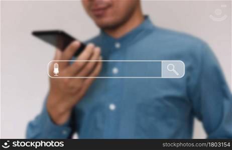 Young businessman wearing light blue shirt use smarthphone in home. Recording audio search data on internet and holding voicemail distant conversation with colleagues. background transparent screen