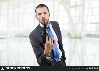 young businessman with a gun, at the office