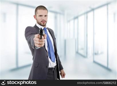 young businessman with a gun, at the office