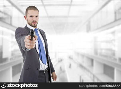 young businessman with a gun, at the office