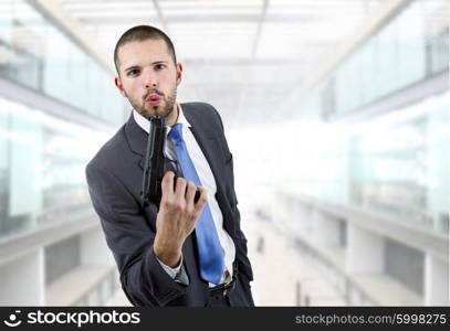 young businessman with a gun, at the office