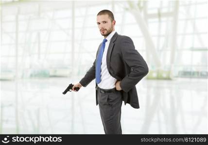 young businessman with a gun at the office