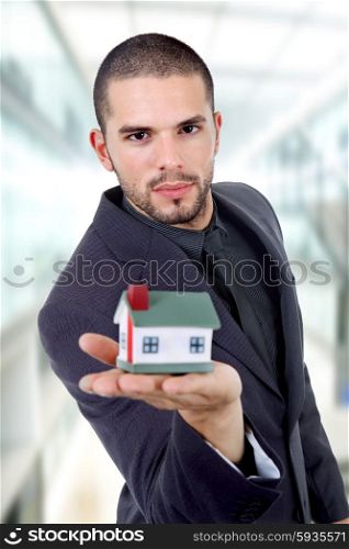 young businessman with a small house in his hand