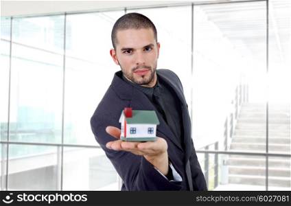 young businessman with a small house in his hand