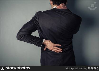Young businessman with a sore neck and back