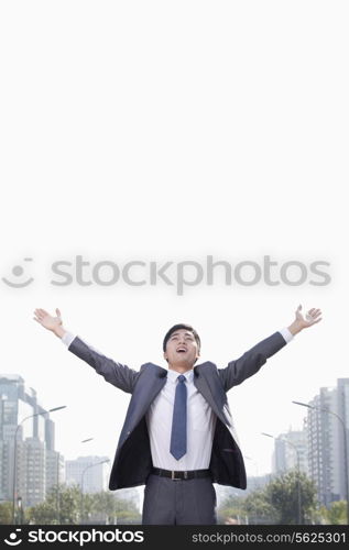 Young Businessman with Arms Raised