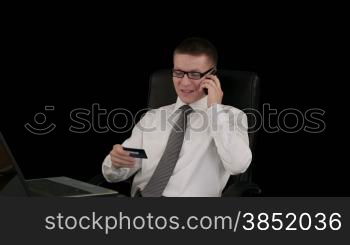 Young businessman with credit card on the phone