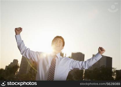 Young businessman with fists in the air celebrating