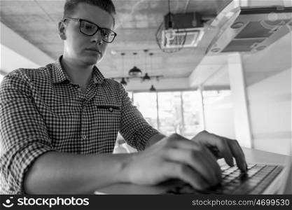 young businessman with glasses at startup business office space working on modern laptop computer