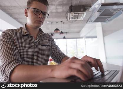 young businessman with glasses at startup business office space working on modern laptop computer