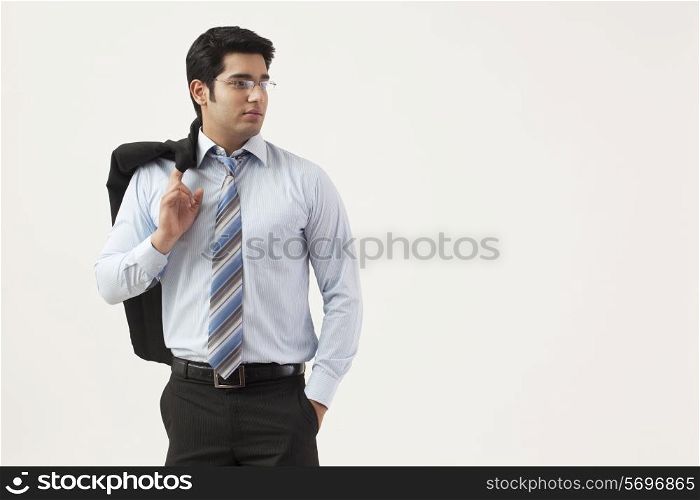 Young businessman with hand in pocket looking away