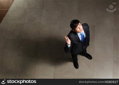 Young businessman with his eyes closed. Image of young businessman with his eyes closed thumb up. Top view