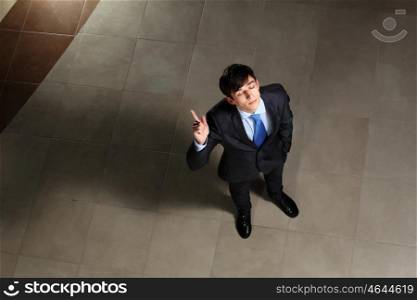 Young businessman with his eyes closed. Image of young businessman with his eyes closed thumb up. Top view