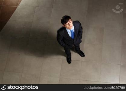 Young businessman with his eyes closed. Image of young businessman with his eyes closed looking above. Top view