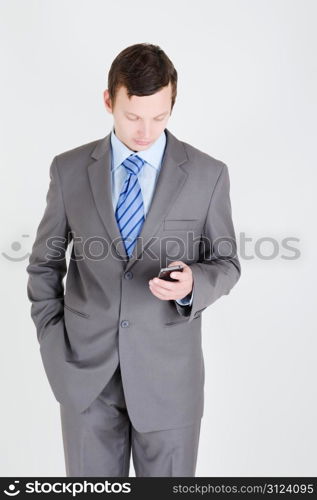 Young businessman with mobile phone and his hand in the pocket