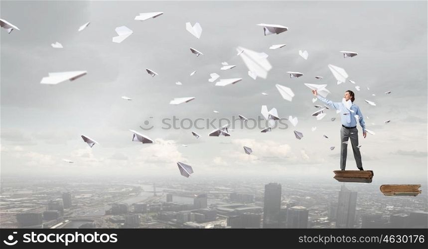 Young businessman with paper plane in hand