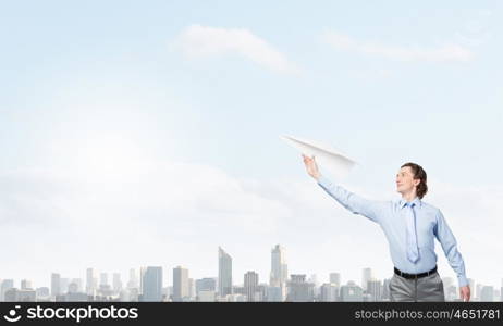 Young businessman with paper plane in hand