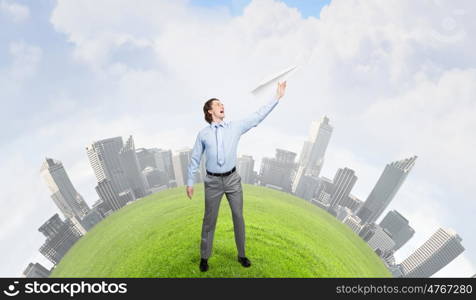 Young businessman with paper plane in hand