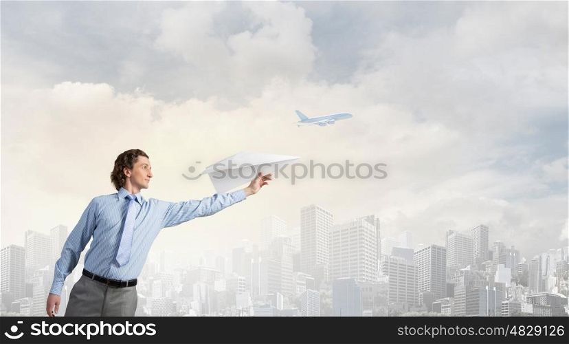 Young businessman with paper plane in hand