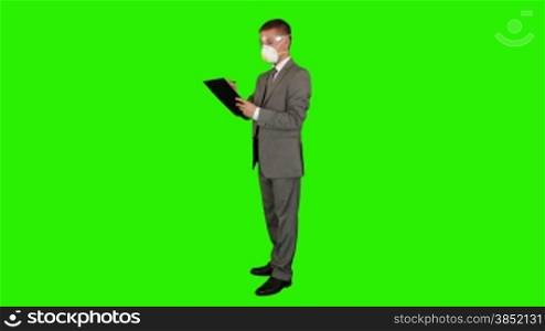 Young businessman with protective glasses and mask taking notes, Green Screen