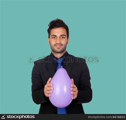 Young businessman with purple balloon on a green background