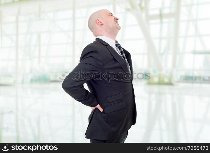 Young businessman with strong back pain, at the office