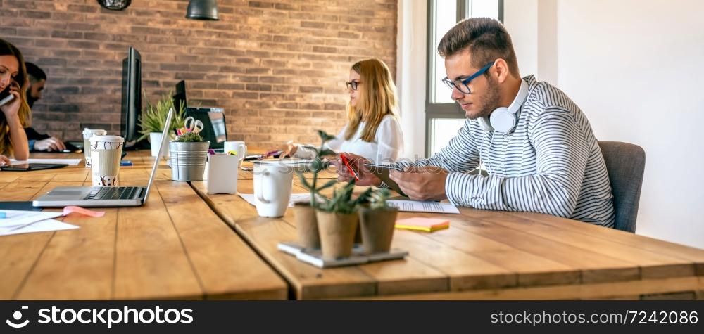 Young businessman working in a coworking office with his colleagues. Businessman working in a coworking office
