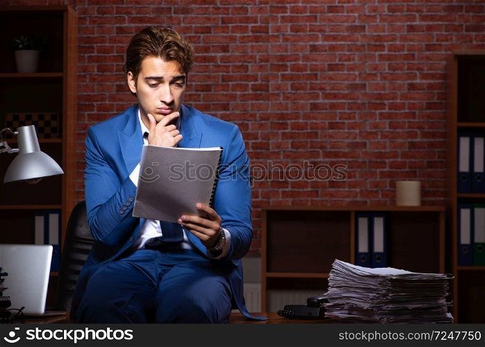 Young businessman working in the office at night . The young businessman working in the office at night 