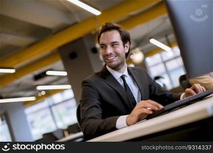 Young businessman working on computer at  modern office
