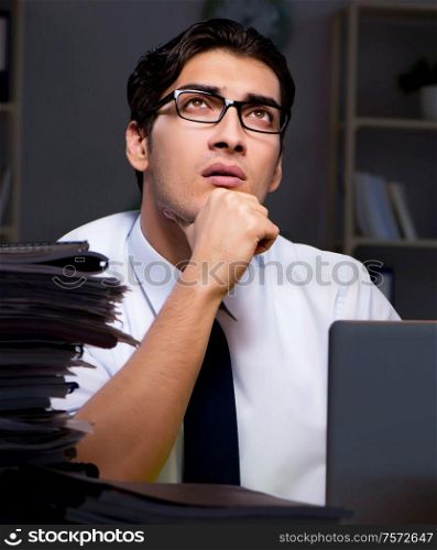 Young businessman working overtime late in office. The young businessman working overtime late in office