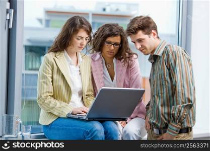 Young businesspeople having meeting at office, working in team together on laptop computer.