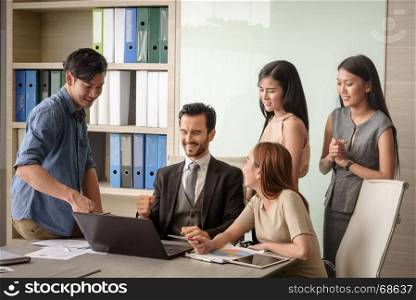 young businesspeople, man and woman, look at laptop for business project in the meeting