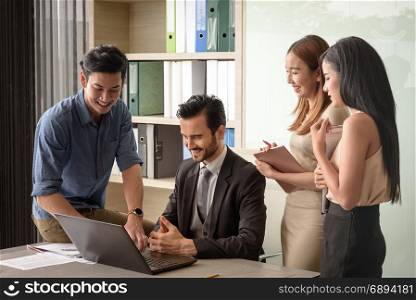 young businesspeople, man and woman, look at laptop for business project in the meeting