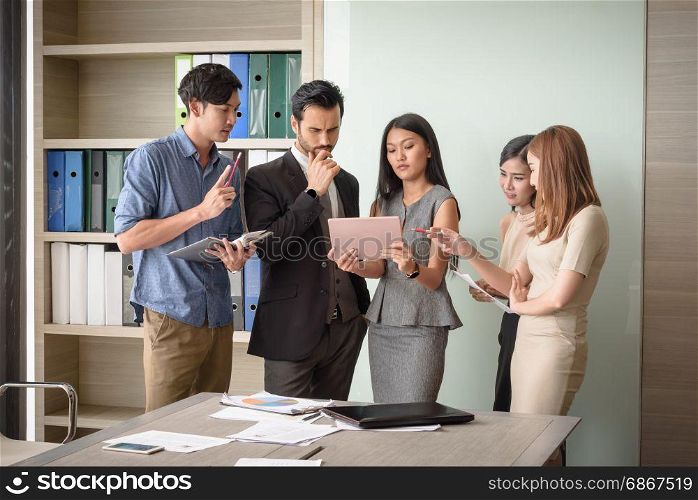 young businesspeople, man and woman, look at tablet for business project in the meeting