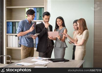 young businesspeople, man and woman, look at tablet for business project in the meeting