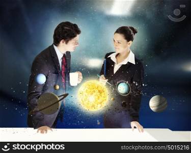 Young businesswoman and businessman and planets of space spinning around. Man and woman with the planets on table