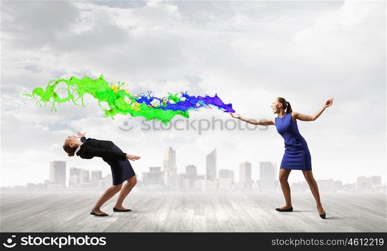 Young businesswoman benting from color paint splashes
