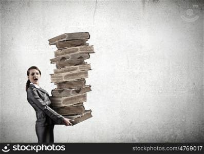 Young businesswoman carrying pile of old books. Master the science