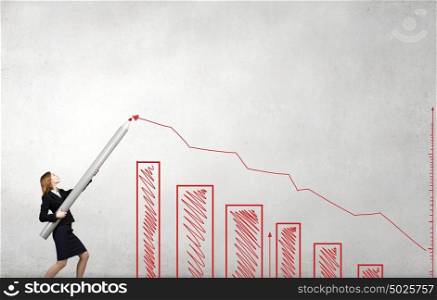 Young businesswoman drawing growing graph with huge pencil. Growth concept