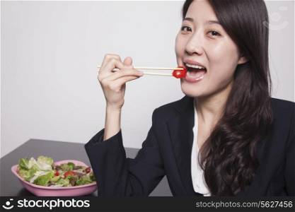 Young businesswoman enjoying a salad, portrait