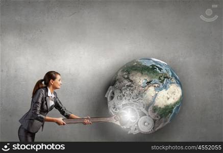 Young businesswoman fixing gears mechanism with wrench. Elements of this image are furnished by NASA. Make it work