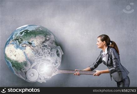 Young businesswoman fixing gears mechanism with wrench. Elements of this image are furnished by NASA. Make it work