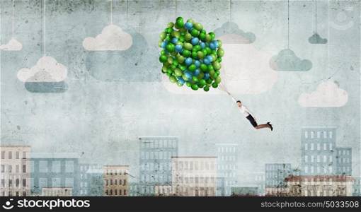 Young businesswoman flying high in sky on bunch of balloons. Woman fly in sky