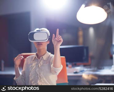 young businesswoman getting experience using VR-headset glasses of virtual reality at late night startup office building