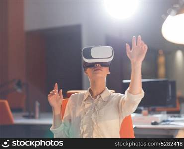 young businesswoman getting experience using VR-headset glasses of virtual reality at late night startup office building