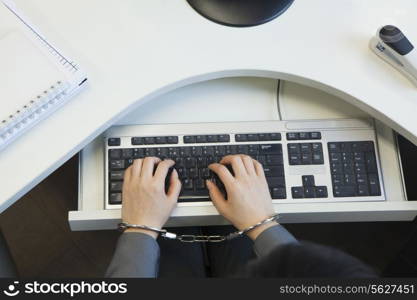 Young businesswoman handcuffed to her office chair, directly above