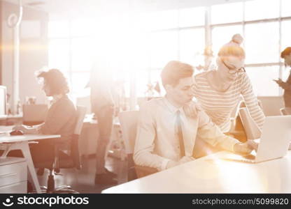 Young businesswoman helping his colleague to fix the problem at the work